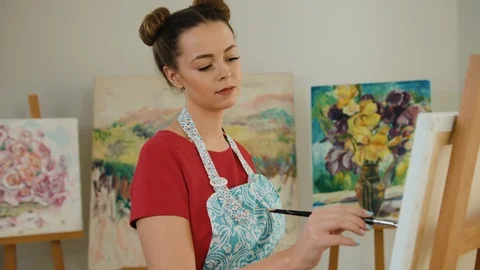 Beautiful painter holding paintbrush in hands and posing on camera while working Stock Footage 74195940