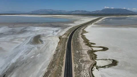 Beautiful Pan Up to Empty Road Crossing Water to Mountain Salt Lake City Utah Stock Footage 154118011