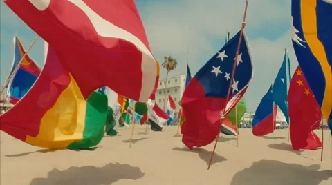 Beautiful pan of flags from different countries on the beach Stock Footage 63445696