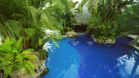 Beautiful pan of pool under trees at vacation spot Stock Footage 49141572