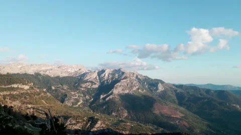Beautiful panoramic view of mountain peaks with clouds on a sunny day, 4k Stock Footage 217990949