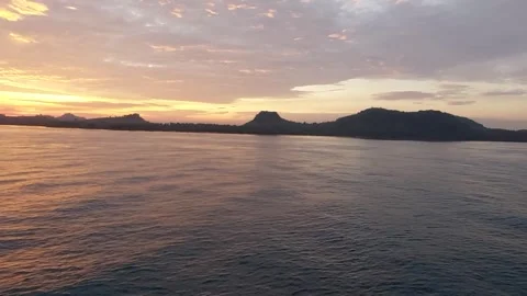 Beautiful Panoramic View of the Sunset Behind an Island in the Wide Ocean Stock Footage 241132151