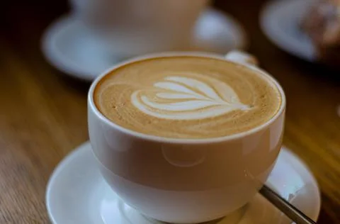 Beautiful pattern on coffee foam made by barista in a white glass with hot latte Foto stock