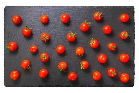 Beautiful pattern of red tomatoes cherry on black slate background, close up, Foto stock