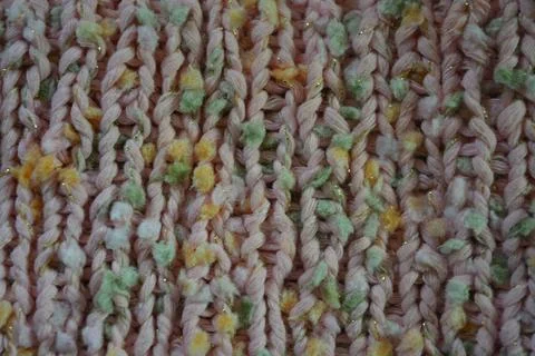 A beautiful patterned background is knitted from pink threads, colored inserts. 写真素材