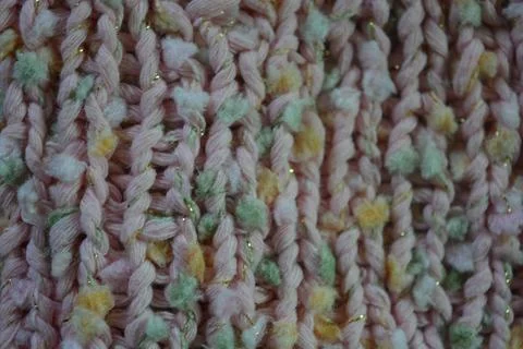 A beautiful patterned background is knitted from pink threads, colored inserts. 写真素材