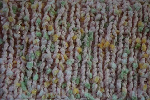 A beautiful patterned background is knitted from pink threads, colored inserts. Foto stock