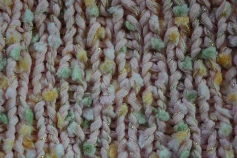 A beautiful patterned background is knitted from pink threads, colored inserts. 写真素材