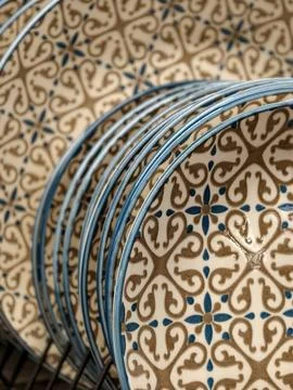 Beautiful patterned ceramic plates with blue rim on shelves in supermarket,.. Stock Photos
