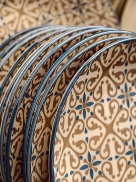 Beautiful patterned ceramic plates with blue rim on shelves in supermarket,.. Stock Photos