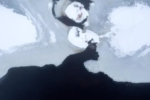 Beautiful patterns of melting ice. Ice washes the water on the lake, melts. Stock Photos