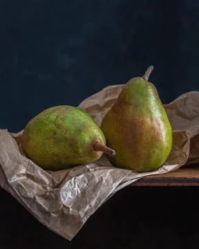 Beautiful pear still life on a paper bag on black background, copy space Stock Photos