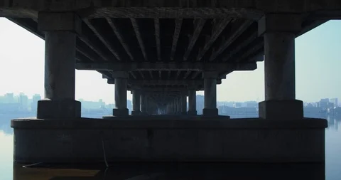 Beautiful perspective under the bridge. Columns with water reflection. Stock Footage 126845839