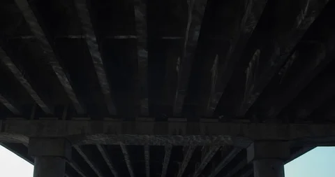 Beautiful perspective under the bridge. Columns with water reflection. Video stock 126845862