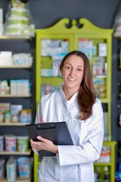 Beautiful pharmacist using notepad at the pharmacy Stock Photos