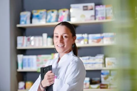 Beautiful pharmacist using notepad at the pharmacy Stock Photos