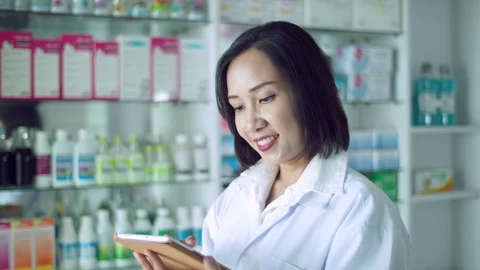 Beautiful  pharmacist using tablet computer Stock Footage 113977171