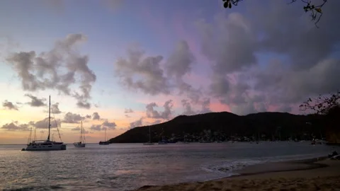 Beautiful pink and blue sky, sailor boats in Bequia harbor, caribbean. Stock Footage