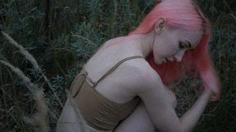 Beautiful pink-haired model poses on nature in swimsuit Stock Footage 100603999