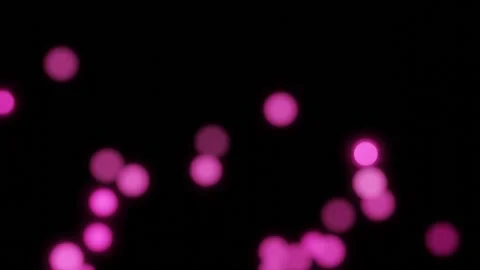 Beautiful pink shimmering particles with lens flare on black background in slow  Stock Footage