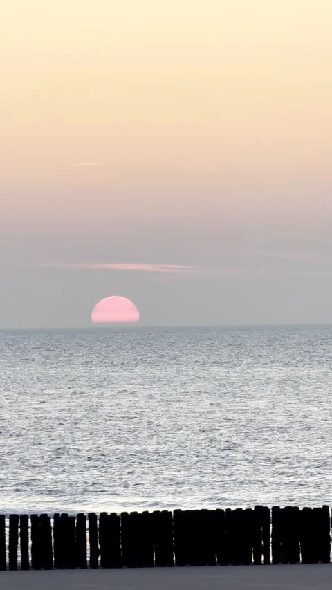 Beautiful Pink Sun Setting Over a Calm Ocean Horizon Video stock 331981279