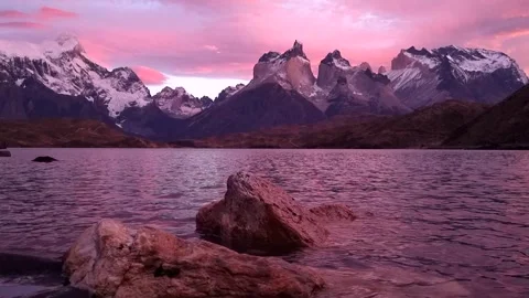 Beautiful pink sunset with view on mountain lake with scenic rocks on first plan Stock Footage 242704190