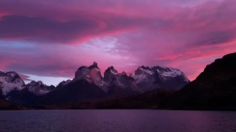 Beautiful pink sunset with view on mountain lake with scenic rocks on first plan Stock Footage 242704441