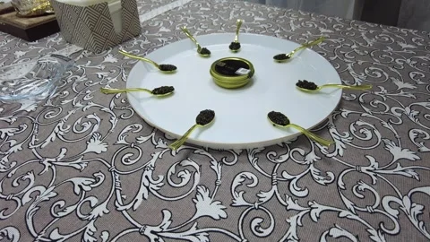 A beautiful plate of caviar elegantly presented, accompanied by shiny spoons, aw Stock Footage 344717761