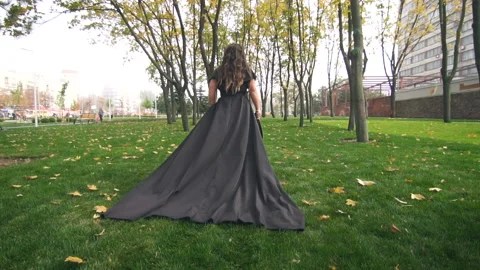 Beautiful plus size model in black long amazing dress at the park Stock Footage 110850083