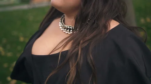 Beautiful plus size model in black long amazing dress at the park Stock Footage 110850175
