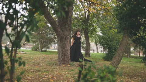 Beautiful plus size model in black long amazing dress at the park Stock Footage 110850234