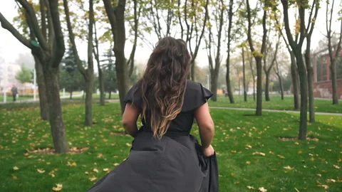 Beautiful plus size model in black long amazing dress at the park Stock Footage 110850386
