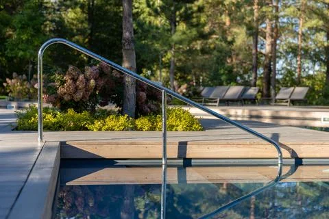 A Beautiful Poolside View with a Reflective Surface and Stylish Handrail Stock Photos