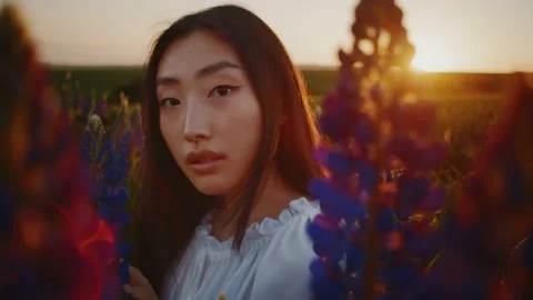 Beautiful portrait of inspired pretty young asian woman standing among lavender Stock Footage 157542753