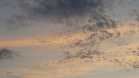 A beautiful pre-sunset sky with light cumulus clouds painted in soft golden Stock Footage 337838224