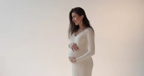 Beautiful pregnant mother posing in the studio on a white background. Stock Footage 253383010