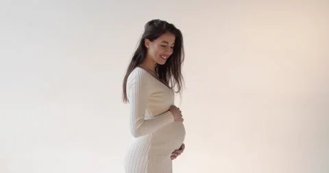 Beautiful pregnant mother posing in the studio on a white background. Stock Footage 253385482