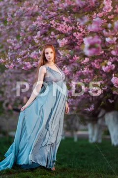 Beautiful pregnant woman in blooming garden Stock Photos