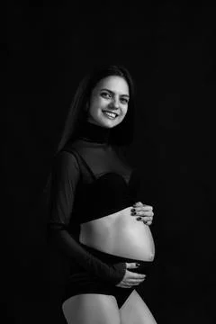 Beautiful pregnant woman in dress holding her belly Stock Photos