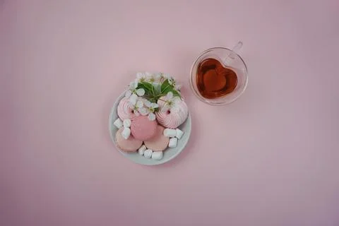 Beautiful presentation on a pink background of sweets and tea in a cup in the Stock Photos