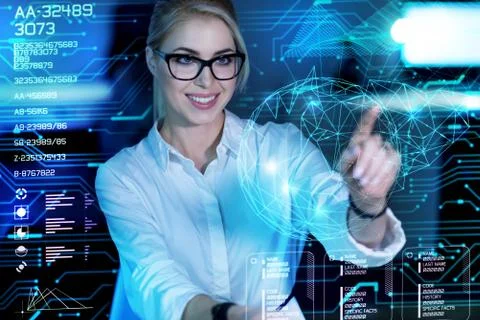 Beautiful programmer touching a transparent screen and looking happy Stock-Fotos