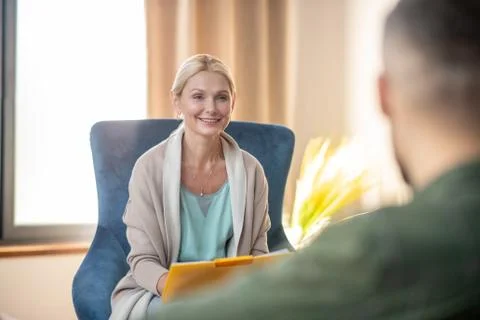 Beautiful psychoanalyst smiling while talking to client Stock Photos