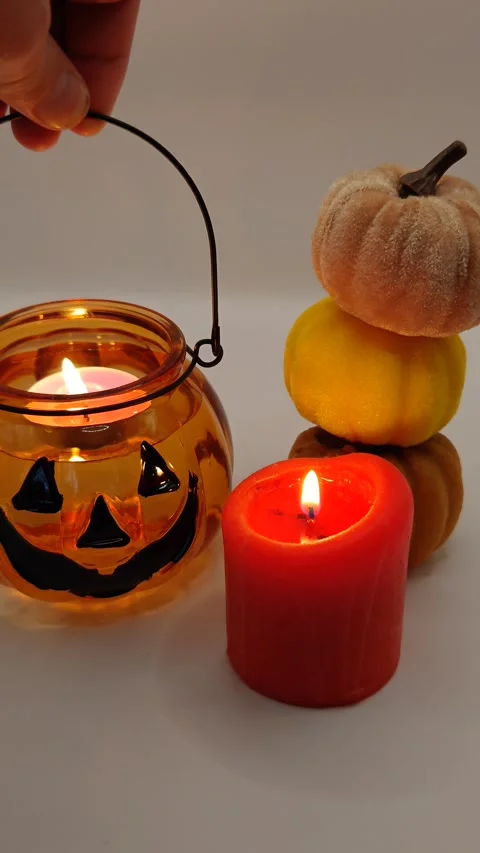 A beautiful pumpkin-shaped candle in hand. Halloween holiday decor. Stock Footage 319789632
