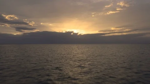 Beautiful push forward over ocean towards perfect sunset, rises at end  Stock Footage 112696363