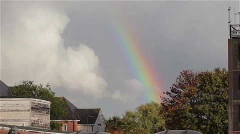 Beautiful Rainbow Breaking Through the Clouds in Blue Sky Above Rooftop View Video stock 42726793