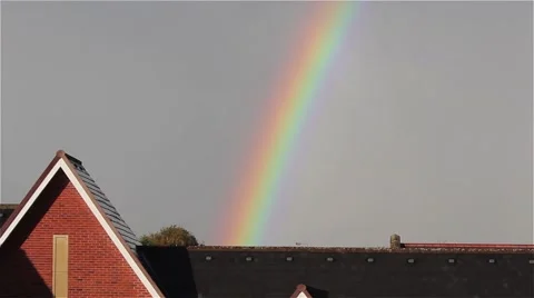 Beautiful Rainbow Breaking Through the Clouds in Blue Sky Above Rooftop View Stock-Footage 42726820