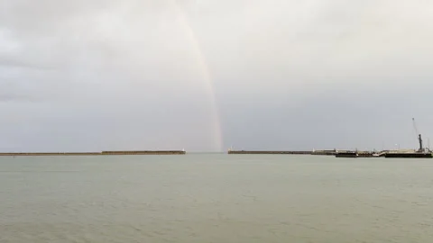 Beautiful rainbow spanning wide harbor entrance 4K Stock Footage 336521724