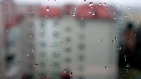 Beautiful raindrops gently landing on window glass with a lovely blurred Video stock 306013201