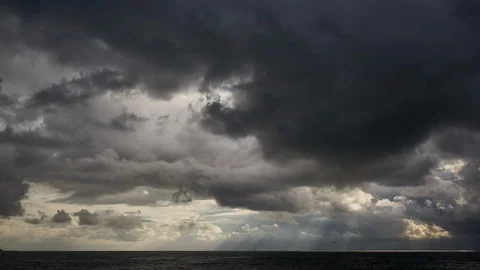 Beautiful rays of the sun break through the clouds above the surface of the sea Stock Footage 116673236
