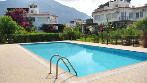 Beautiful rectangular outdoor pool with blue turquoise water and a villa Vidéo 134613747